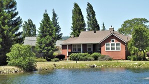 A house with a red exterior, a front porch, and a small pond in front. - Raspberry Cottage-stunning view of golfcourse (Angels Camp)