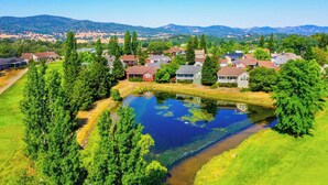 A residential area with houses, a pond, and surrounding greenery. - Raspberry Cottage-stunning view of golfcourse (Angels Camp)