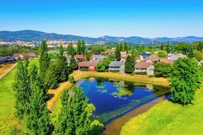 A residential area with houses, a pond, and surrounding greenery. - Raspberry Cottage-stunning view of golfcourse (Angels Camp)
