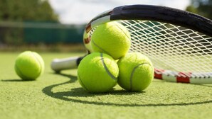 A tennis racket and three tennis balls on a green surface. - Raspberry Cottage-stunning view of golfcourse (Angels Camp)