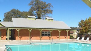 A swimming pool with lounge chairs and a covered pavilion. - Raspberry Cottage-stunning view of golfcourse (Angels Camp)