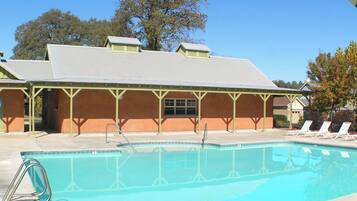 A swimming pool with lounge chairs and a covered pavilion.