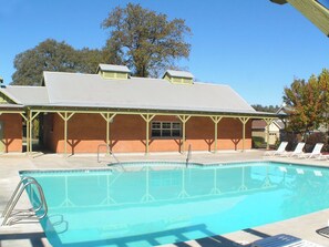 A swimming pool with lounge chairs and a covered pavilion. - Raspberry Cottage-stunning view of golfcourse (Angels Camp)