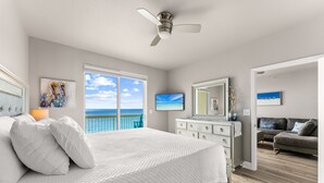 A bedroom with a bed, a dresser, a ceiling fan, a large window with a view of the ocean, and a balcony. - GULF FRONT BEDROOM @ CELADON BEACH RESORT ~FREE Beach Chair Service! (Panama City Beach)