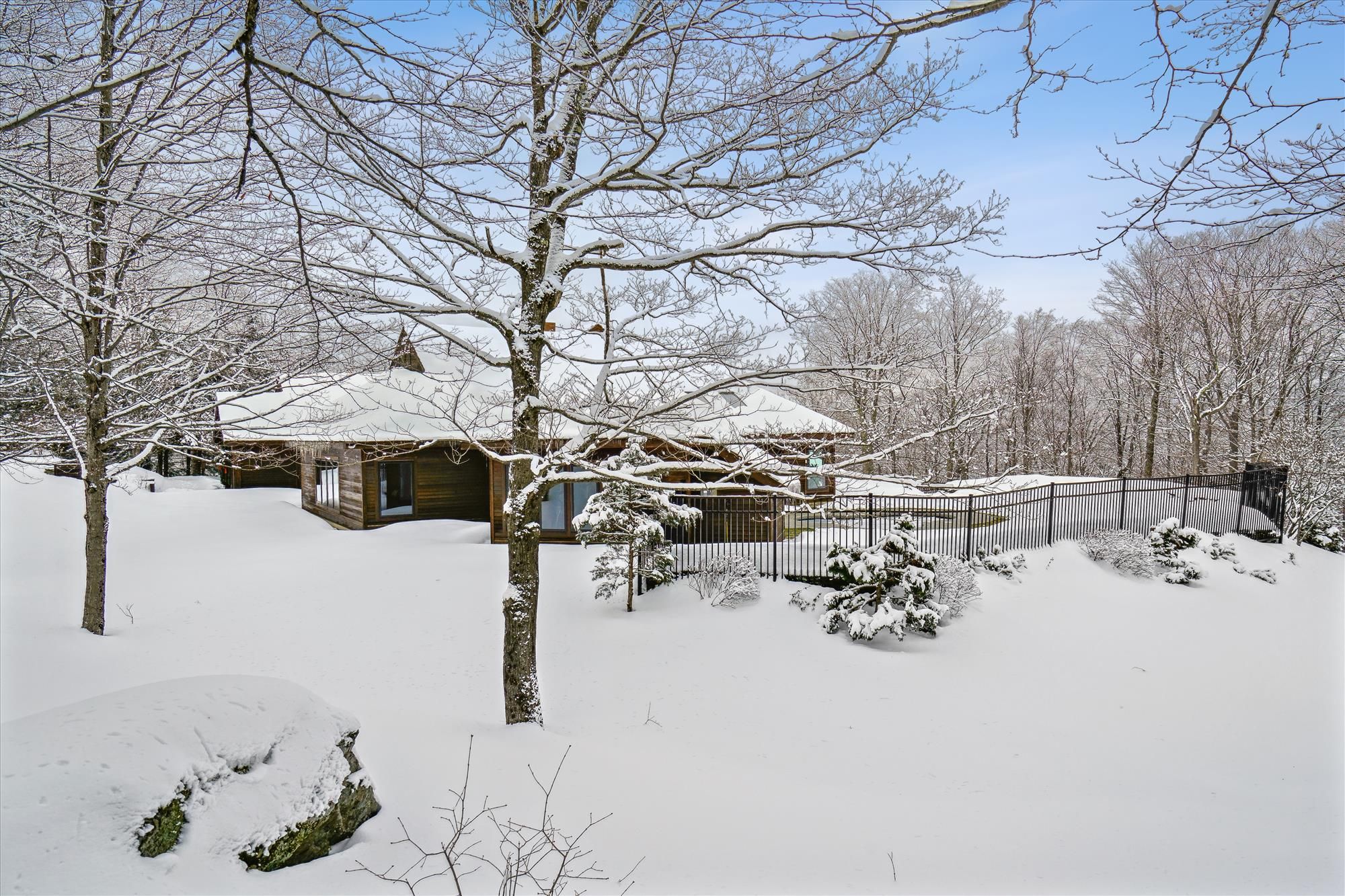 A wooden cabin surrounded by snow-covered trees.