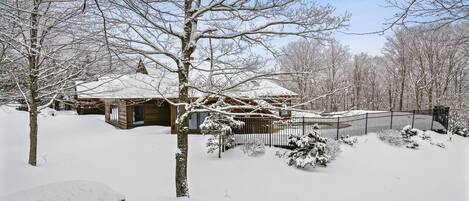 A wooden cabin surrounded by snow-covered trees.
