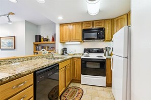Kitchen equipped with a dishwasher, microwave, oven, and refrigerator.