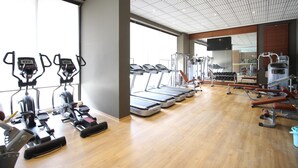 A gym with treadmills, elliptical machines, and weight equipment. - Mirage Residences - 2 Bedroom Unit (Accra)