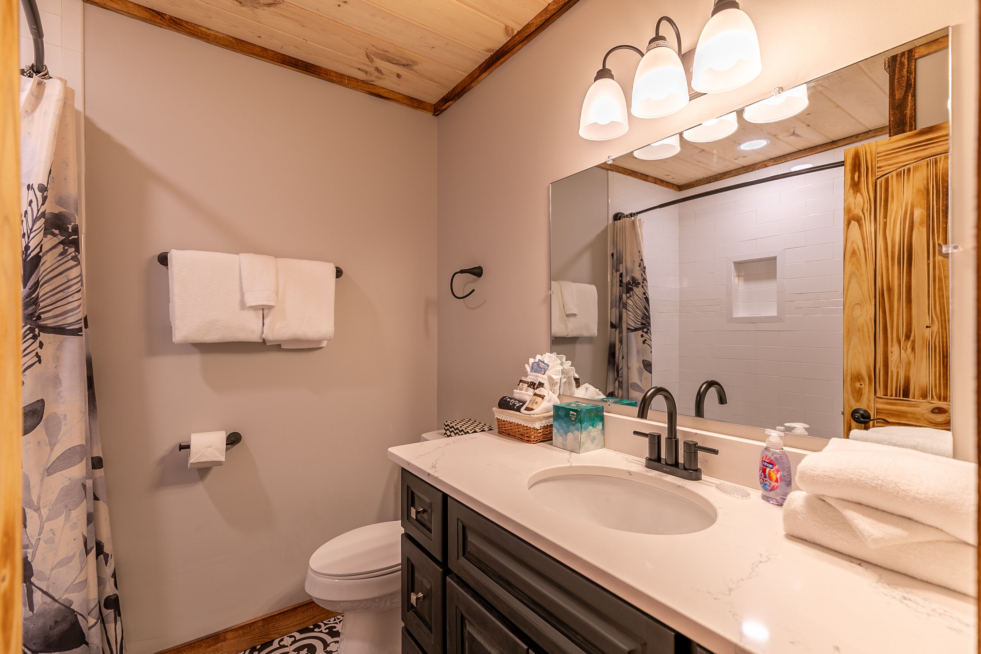 A bathroom with a sink, mirror, towel rack, and toilet.