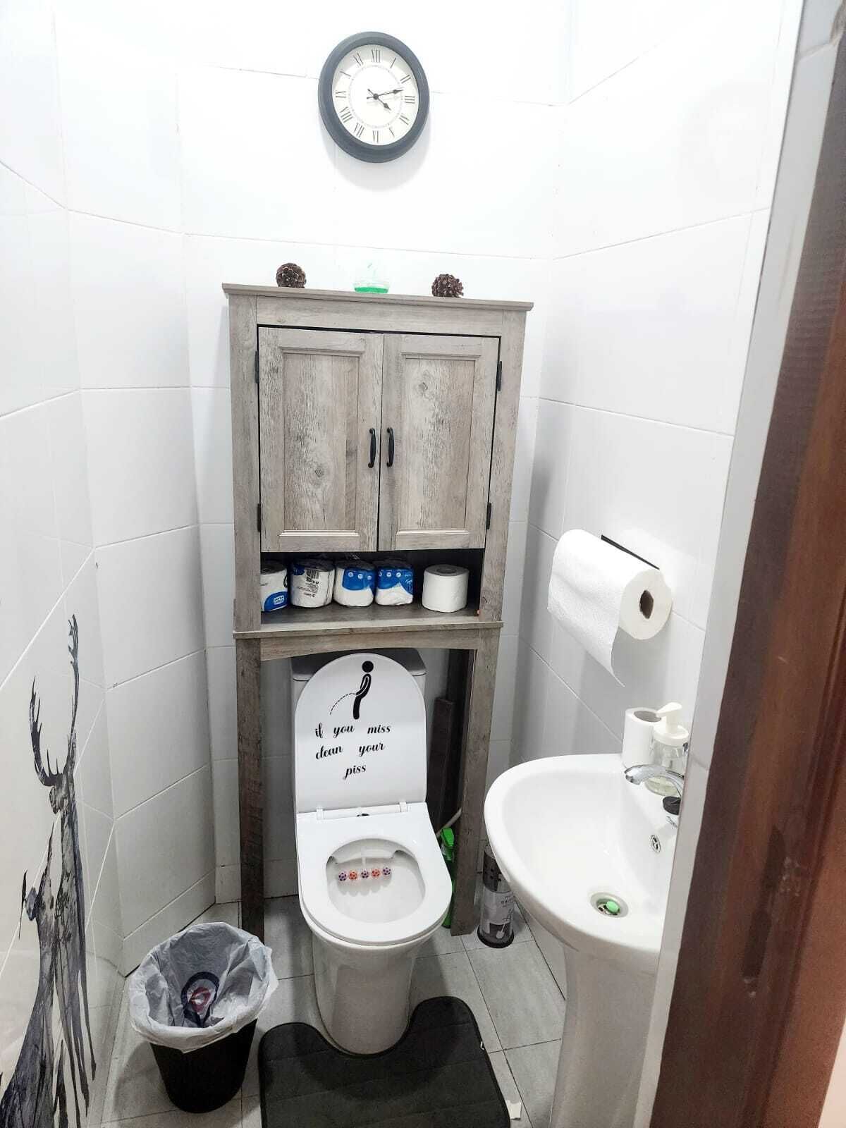 Une petite salle de bain avec des toilettes, un lavabo et un meuble de rangement.