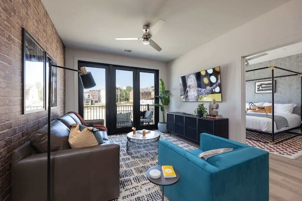 Welcome to a bright and open concept living room that exudes modern elegance. Designer furnishings enhance the sophistication of the space, while a smart TV provides entertainment options and a pull-out couch.