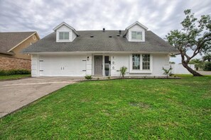 A single-story house with a garage, a front lawn, and a tree to the right.