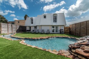 A two-story house with a swimming pool, a barbecue area, and a well-maintained lawn. - Ocean Drive Splendor Awaits (Corpus Christi)