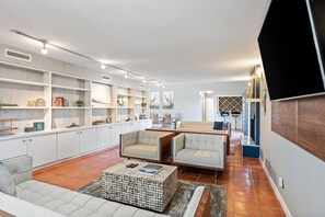 A spacious living area with a sofa, two armchairs, a coffee table, and built-in shelving. - Ocean Drive Oasis w Hot Tub Awaits (Corpus Christi)
