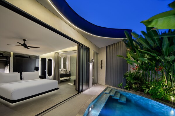 A modern bedroom with a large bed, a ceiling fan, and a view of the bathroom. - Je Ne Sais Quoi Seminyak (Seminyak)