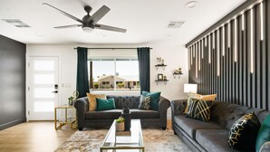 Ein modernes Wohnzimmer mit einer Couch, einem Couchtisch und einem Deckenventilator.
