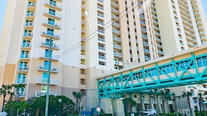 Un hotel moderno de gran altura con varios balcones y un puente peatonal.