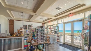 Una tienda junto a la playa con vistas al océano, que ofrece gafas de sol, sombreros y accesorios para la playa.