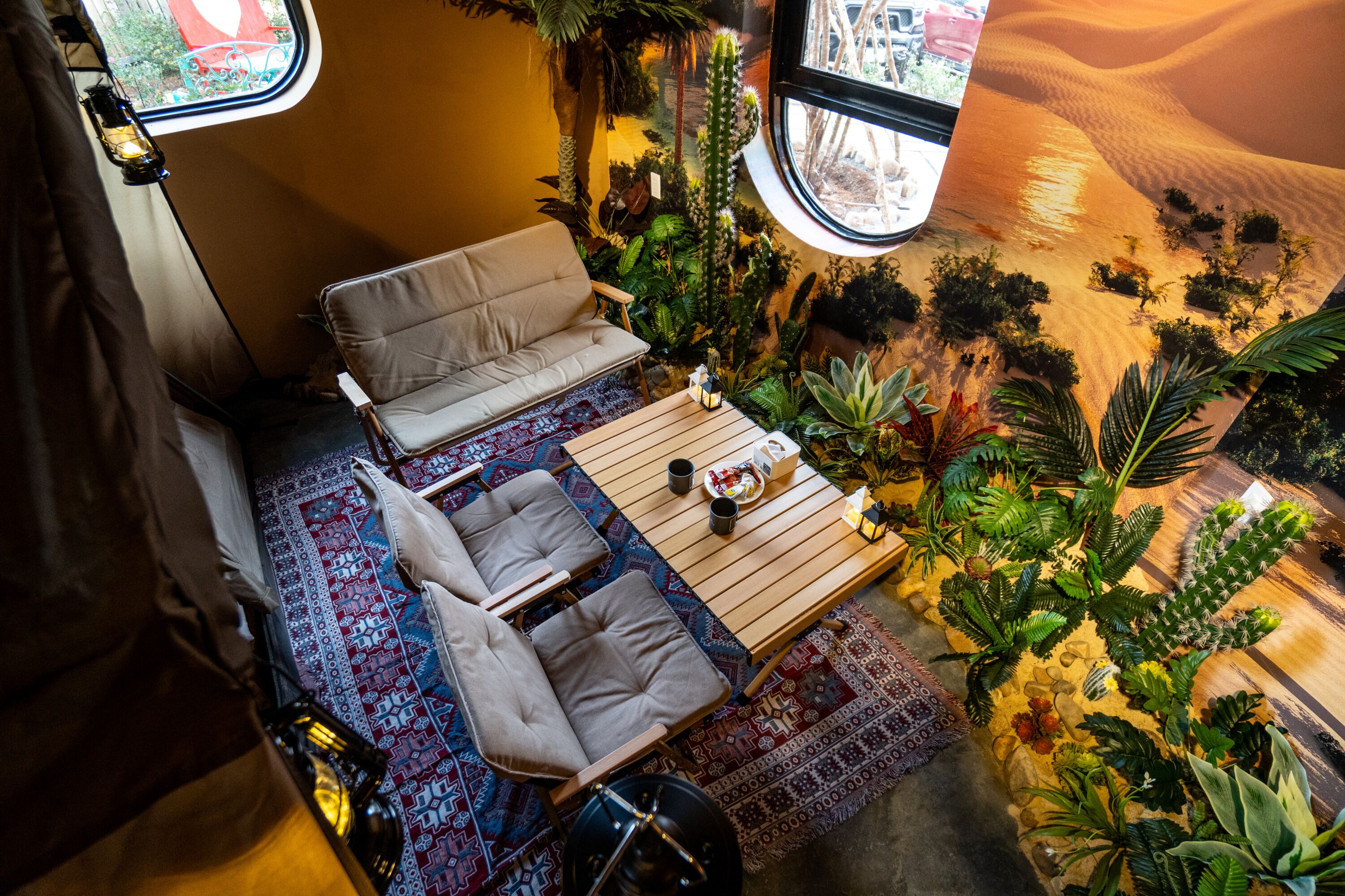 A cozy interior with a sofa, a small table, and a variety of plants.