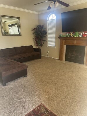 Relax in this inviting living room with a sofa, ottoman, and flat-screen TV.