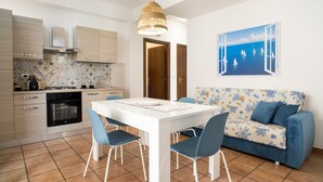 A modern kitchen with a dining table, chairs, and a sofa. - Apartment 'La Casa Di Terry' with Balcony and Air Conditioning (Acireale)