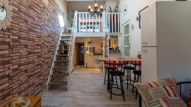 A multi-level home interior with a kitchen, dining area, and a staircase.