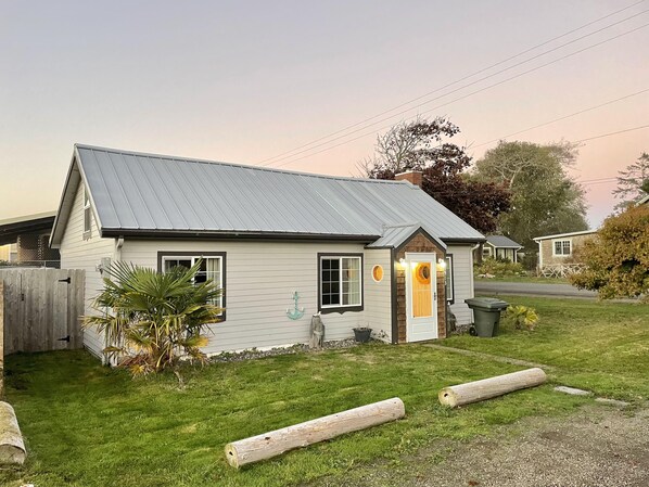 A small, single-story house with a metal roof and a front porch.