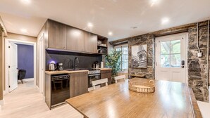 A modern kitchen with dark wood cabinets, a central island, and a dining table.