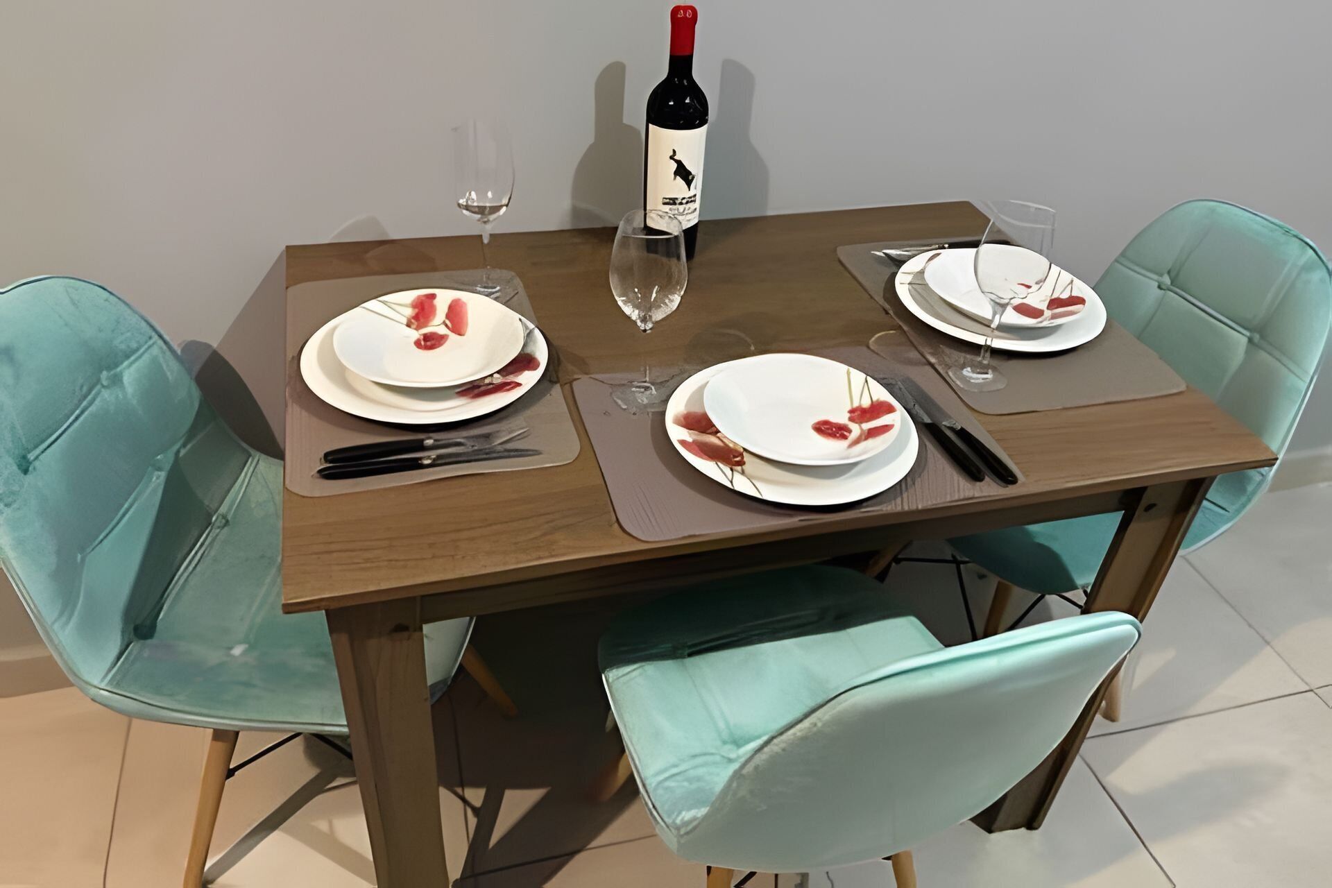 A dining table with plates, cutlery, and a wine bottle.