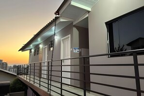 Un bâtiment moderne doté d’un balcon, d’une porte et d’une fenêtre.