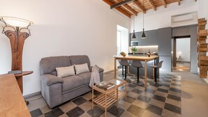 A modern living room with a sofa, coffee table, and a dining area with chairs and a table. - NEW! Design & Modern Flat in Trastevere (Roma)