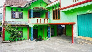 A two-story house with a balcony, a satellite dish, and a satellite dish on the roof. - OYO 92997 Villa Hj Karnadi (Cisarua)