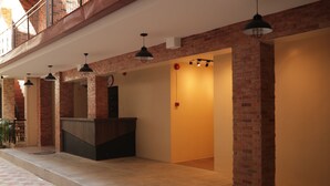 A hotel lobby with brick columns, a reception desk, and pendant lighting. - Cerca Hotel (Boracay Island)