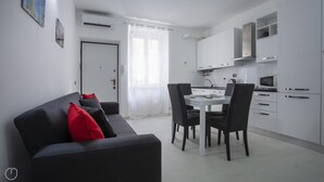 Un appartamento moderno con zona living, sala da pranzo e cucina.