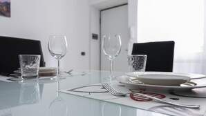 Un tavolo da pranzo con due bicchieri di vino, un piatto e una forchetta.