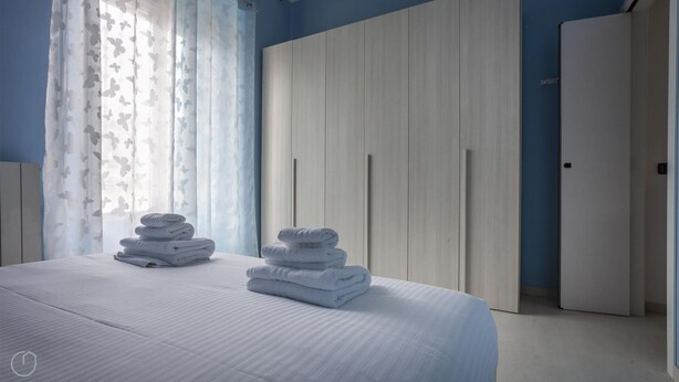 Camera da letto con un letto grande, un armadio e una porta.