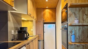 Una cocina moderna con armarios de madera, lavavajillas Bosch, cafetera y refrigerador.