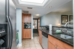 A modern kitchen with a dishwasher, a sink, and a countertop with a tiled backsplash. - Dock Views, Near Beach, Heated Pool, Private Beach (Sarasota)