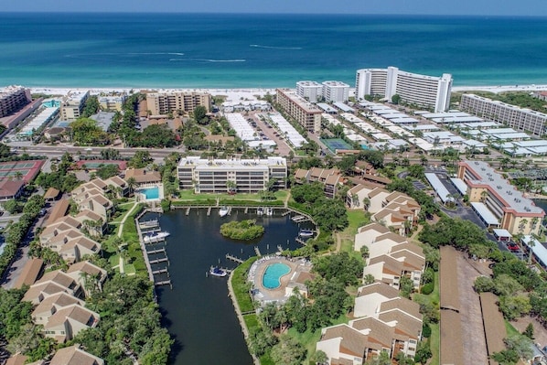 A coastal resort with a marina, swimming pool, and beachfront hotel buildings. - Dock Views, Near Beach, Heated Pool, Private Beach (Sarasota)