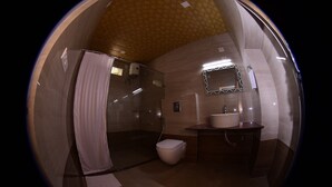 Ein Badezimmer mit Dusche, Toilette, Waschbecken und Spiegel.