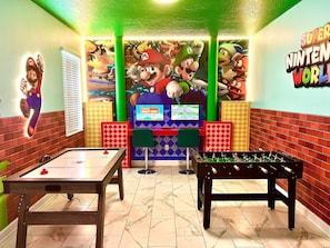 A room with a foosball table, a pool table, and a Nintendo World-themed mural. - Private Pool Modern Elegance Ideal Locale (Davenport)