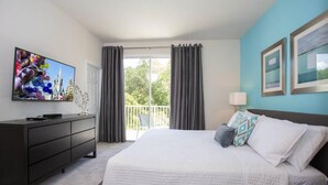 A hotel room with a bed, a TV, a dresser, and a balcony with curtains. - Charming Cozy Haven in Four Corners (Clermont)