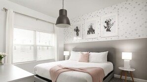 A modern bedroom with a large bed, bedside lamps, and a window with blinds. - Charming Mickey-themed Home Prime Location (Kissimmee)