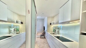 Une cuisine moderne dotée de deux éviers, d’un coin repas et offrant une vue sur le salon.