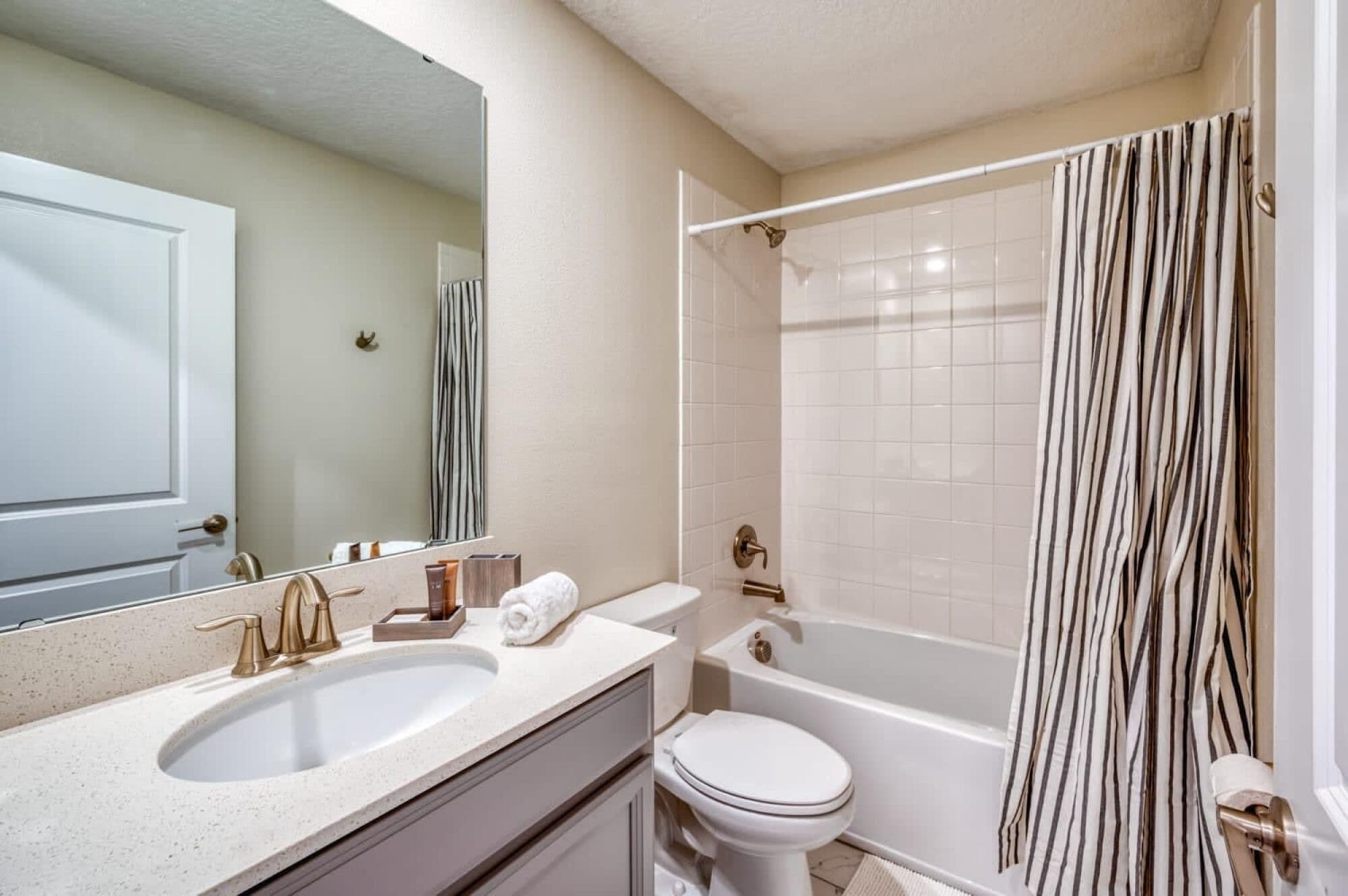 Un baño con lavamanos, inodoro y bañera.