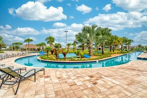 Relax by the pool surrounded by palm trees and lounge chairs.