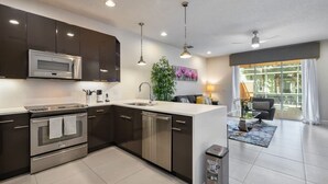 Una cocina moderna con electrodomésticos de acero inoxidable, una isla central y un comedor con vistas.