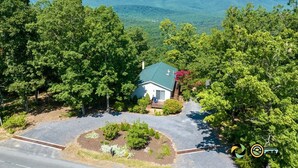 A house surrounded by dense trees with a view of distant hills. - Sparkling Bear Lodge | Epic views! | Touch the stars (Mount Jackson)