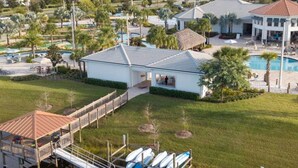 A waterfront property with a dock, swimming pool, and a small building. - Modern Marvel-spacious Themed Fun-filled Family Getaway (Kissimmee)
