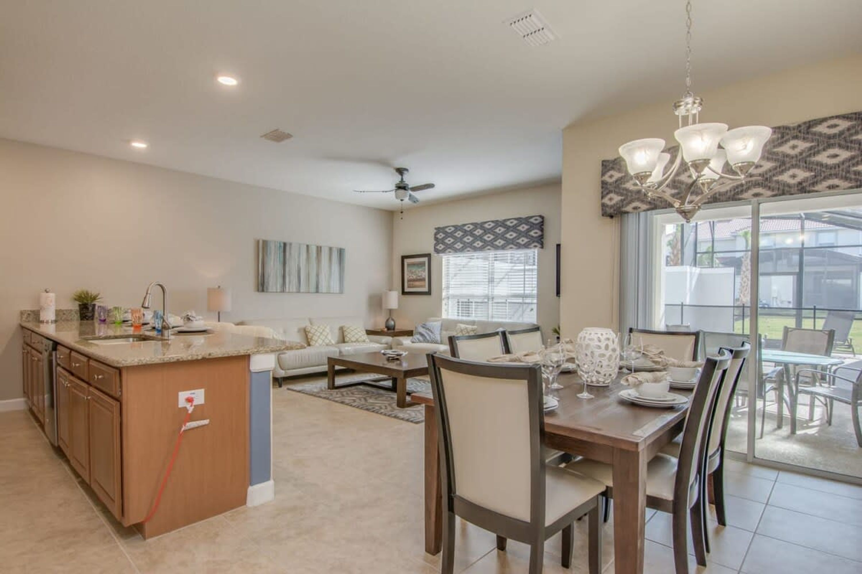 A spacious living area with a kitchen island, dining table, and chairs.